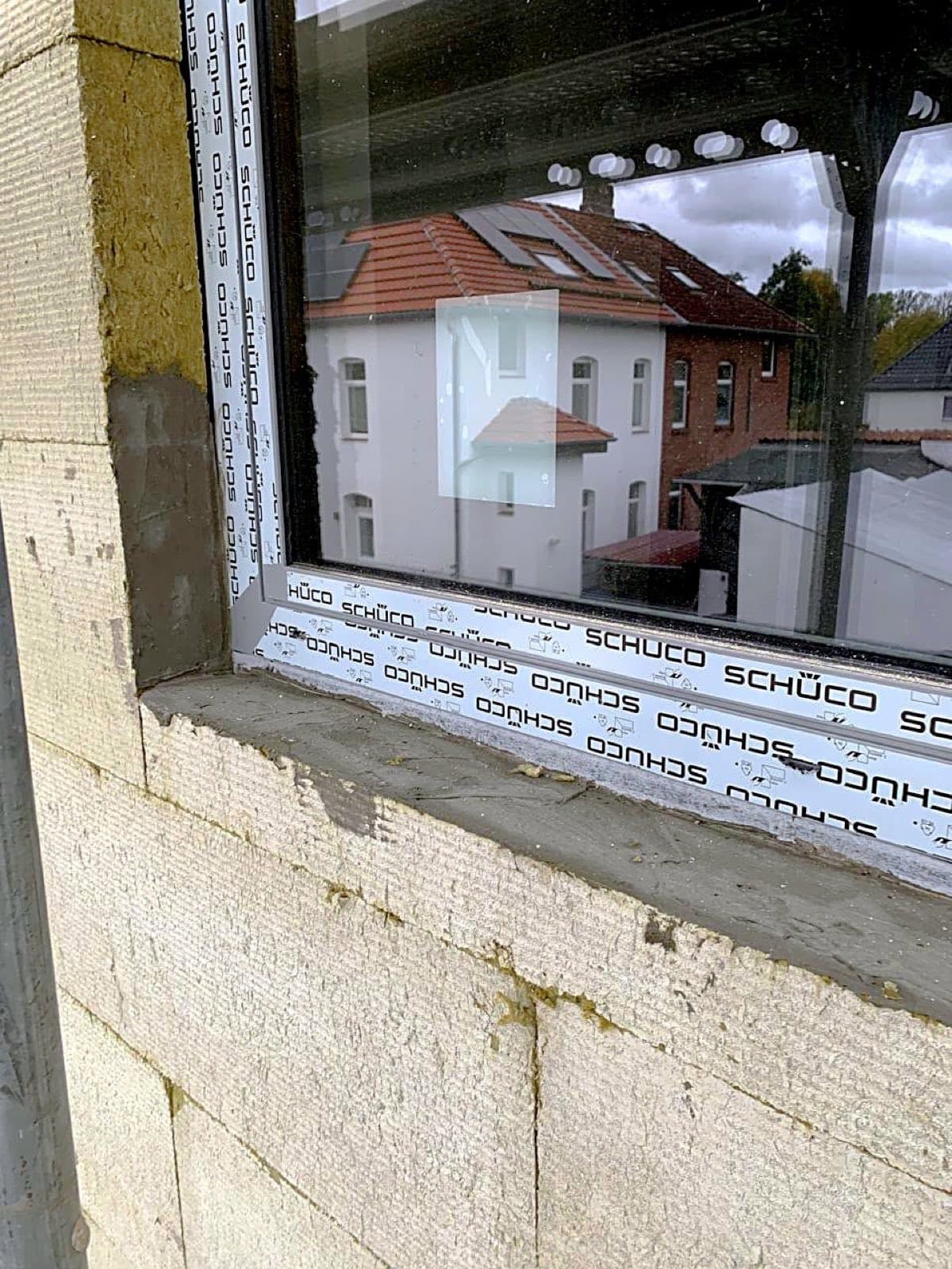 Detailaufnahme einer Fensterlaibung: Dämmung sauber an den Fensterrahmen herangeführt